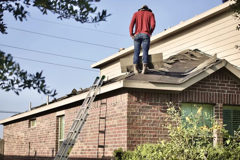 Professional roofer working on a residential roof in Price